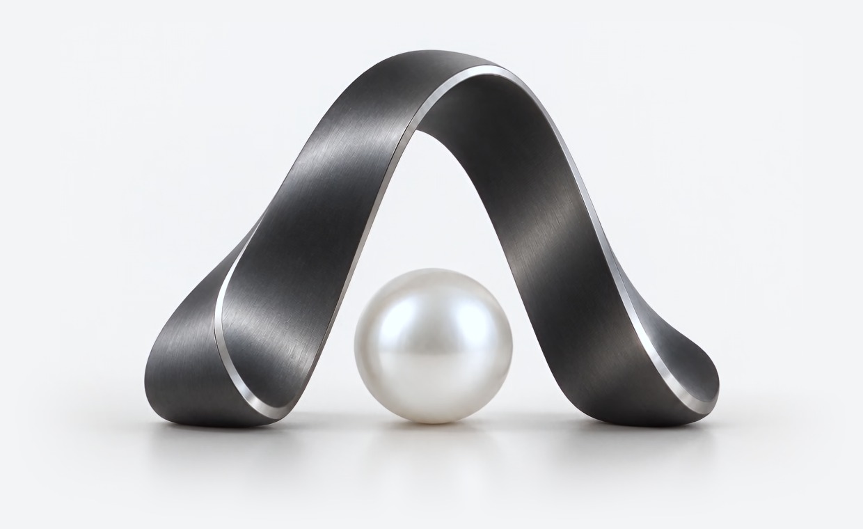 Sculpted graphite Augmora arch with a pearl resting beneath it